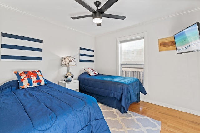 bedroom with ornamental molding, wood finished floors, a ceiling fan, and baseboards