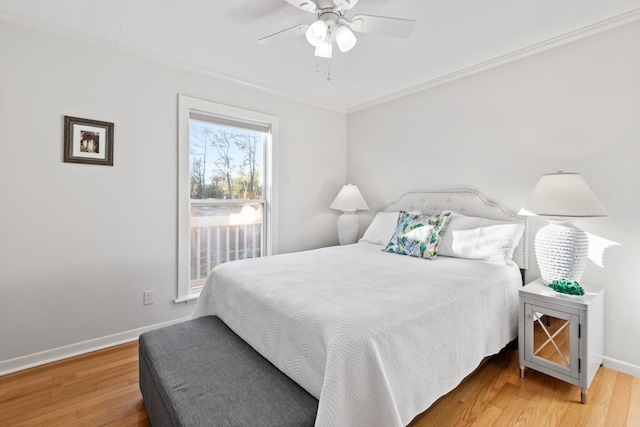 bedroom with ornamental molding, a ceiling fan, baseboards, and wood finished floors