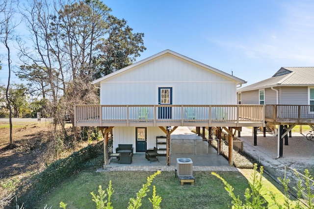 back of property with a patio, a lawn, central AC unit, a carport, and a wooden deck