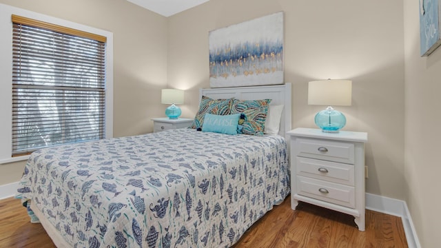 bedroom featuring baseboards and wood finished floors