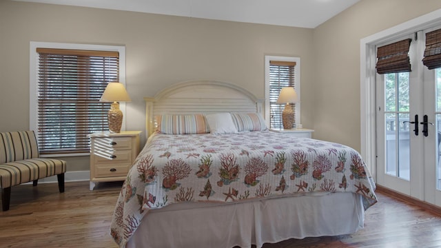 bedroom with access to exterior, french doors, baseboards, and wood finished floors