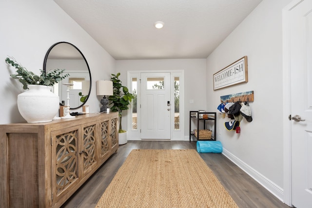 foyer entrance featuring dark wood finished floors and baseboards