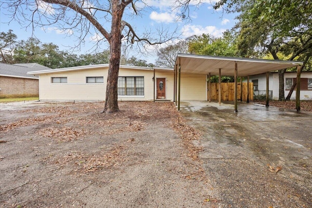 view of front of property with driveway, fence, and a carport