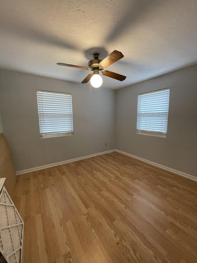 unfurnished room featuring baseboards and light wood-style floors