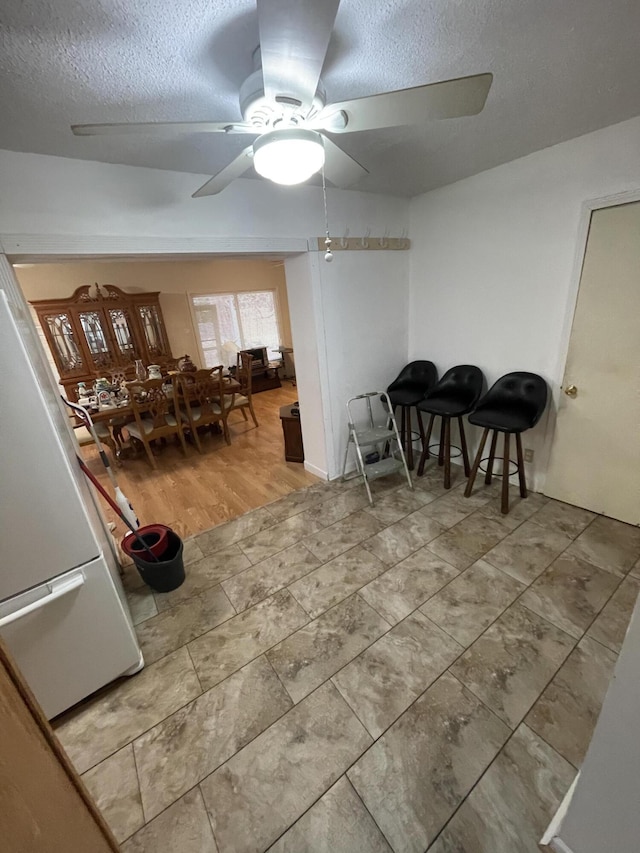 dining room with ceiling fan and a textured ceiling