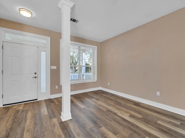 foyer entrance with hardwood / wood-style floors and ornate columns