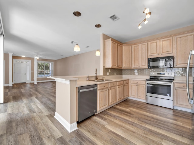 kitchen with stainless steel appliances, pendant lighting, light brown cabinets, sink, and kitchen peninsula