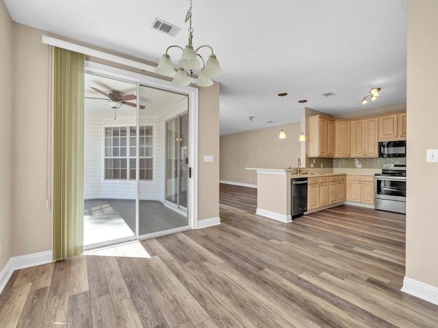 kitchen featuring kitchen peninsula, light hardwood / wood-style flooring, decorative light fixtures, black appliances, and light brown cabinetry