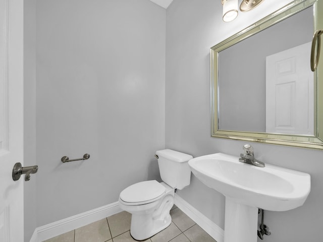 bathroom with toilet and tile patterned flooring