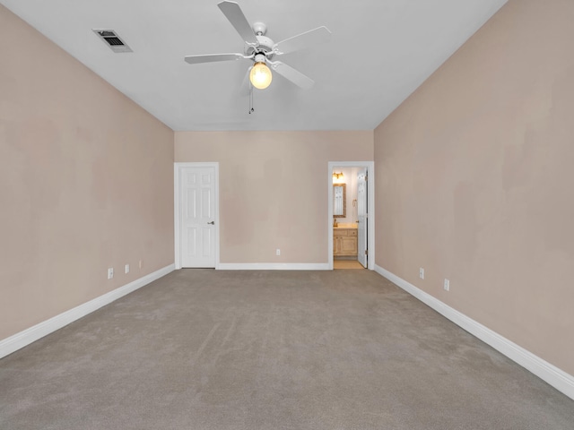 unfurnished bedroom featuring ceiling fan, ensuite bath, and light colored carpet