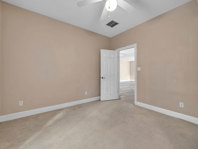 spare room with ceiling fan and light carpet