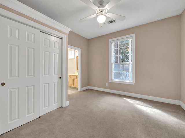 unfurnished bedroom featuring a closet, light colored carpet, and ceiling fan