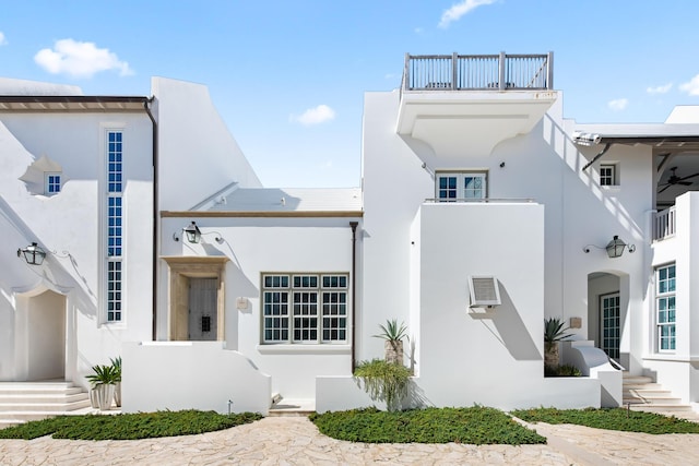 view of side of home with a balcony and stucco siding