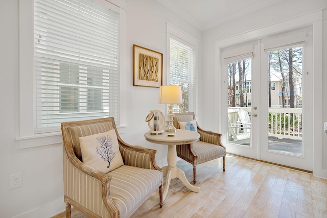 living area featuring light wood finished floors, plenty of natural light, and french doors