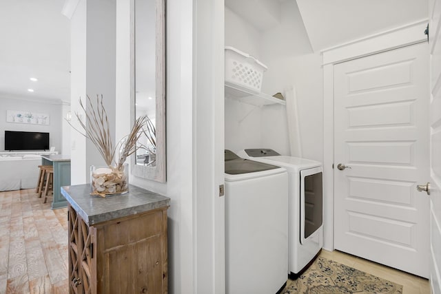 washroom featuring laundry area, washer and clothes dryer, and wood finished floors