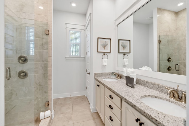 bathroom featuring baseboards, double vanity, a sink, and a shower stall