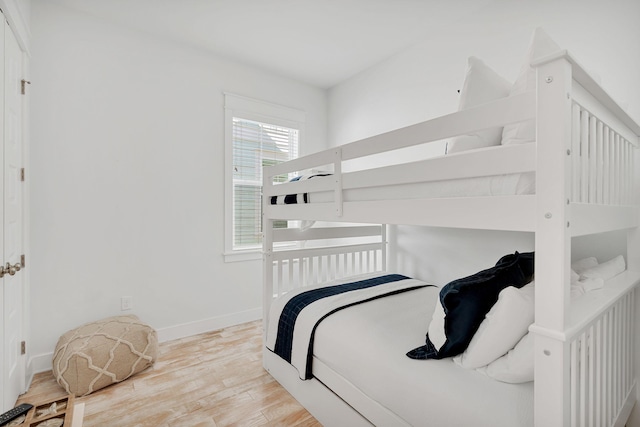 bedroom featuring baseboards and light wood finished floors