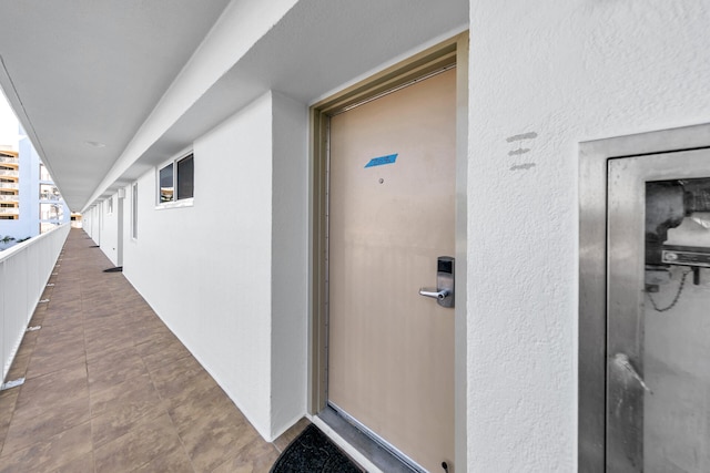 doorway to property with a balcony and stucco siding