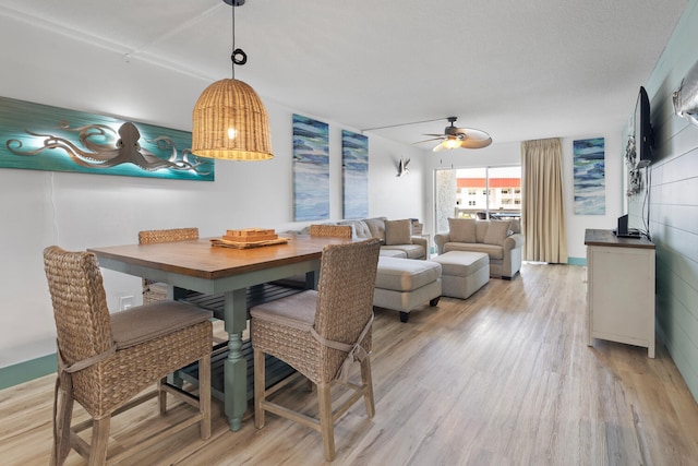 dining space featuring light wood-style flooring and a ceiling fan