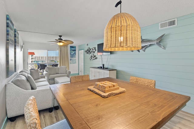 dining room featuring light wood-type flooring, visible vents, and ceiling fan