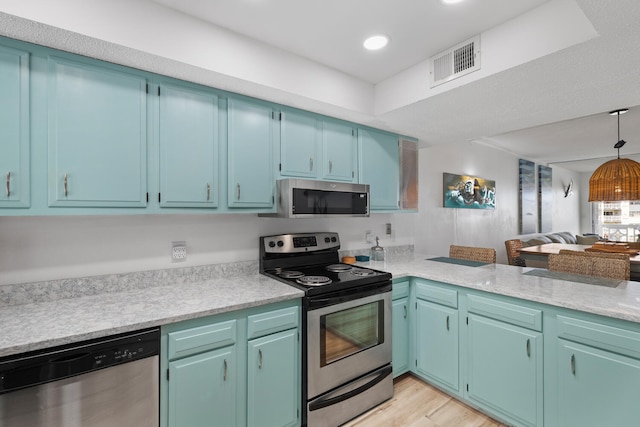 kitchen with visible vents, appliances with stainless steel finishes, open floor plan, light countertops, and light wood-style floors