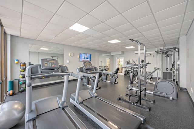 workout area with baseboards, a drop ceiling, and a wall mounted air conditioner