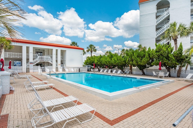 community pool with a patio and stairway