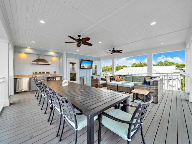 wooden terrace with an outdoor kitchen, area for grilling, ceiling fan, an outdoor hangout area, and outdoor dining area