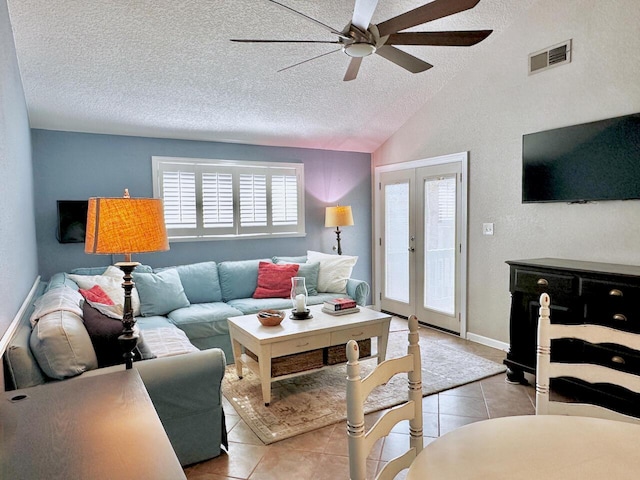 living room with french doors, lofted ceiling, visible vents, light tile patterned flooring, and a textured ceiling