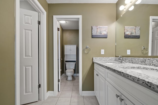 full bath featuring double vanity, baseboards, tile patterned floors, a textured ceiling, and a sink