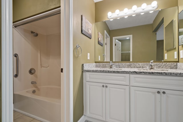 full bathroom featuring double vanity, washtub / shower combination, a sink, and tile patterned floors