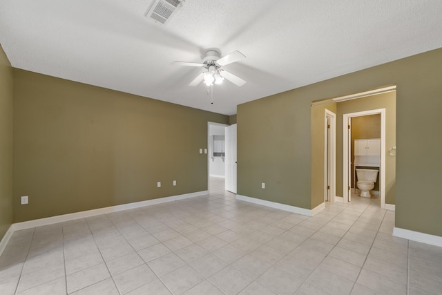 spare room with visible vents, baseboards, a ceiling fan, a textured ceiling, and light tile patterned flooring