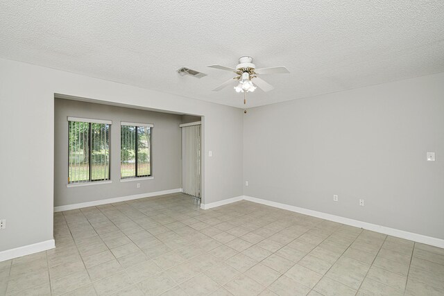 303 Southlake Ct Unit 303, Niceville, FL 32578 - spare room with ceiling fan, light tile patterned floors, a textured ceiling, and baseboards