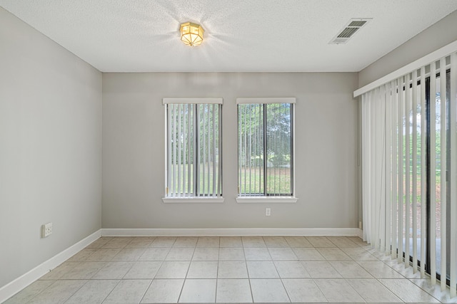 303 Southlake Ct Unit 303, Niceville, FL 32578 - unfurnished room with baseboards, light tile patterned floors, and a textured ceiling