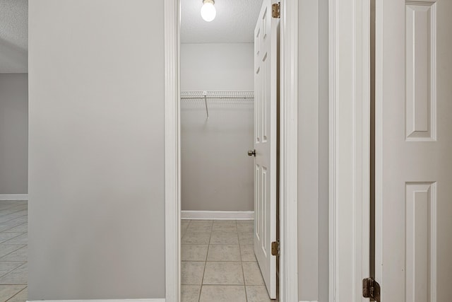 303 Southlake Ct Unit 303, Niceville, FL 32578 - hall featuring a textured ceiling, light tile patterned floors, and baseboards
