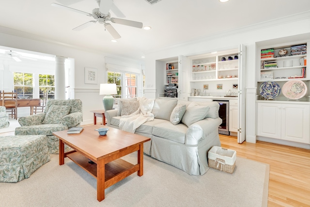 living room featuring a wealth of natural light, beverage cooler, and ornamental molding