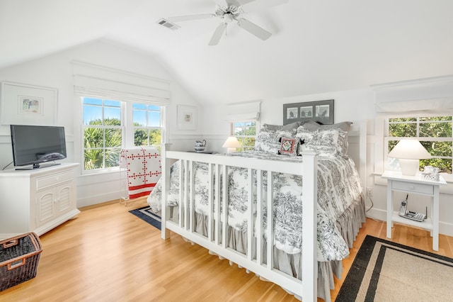 bedroom with visible vents, light wood-style floors, a ceiling fan, and vaulted ceiling