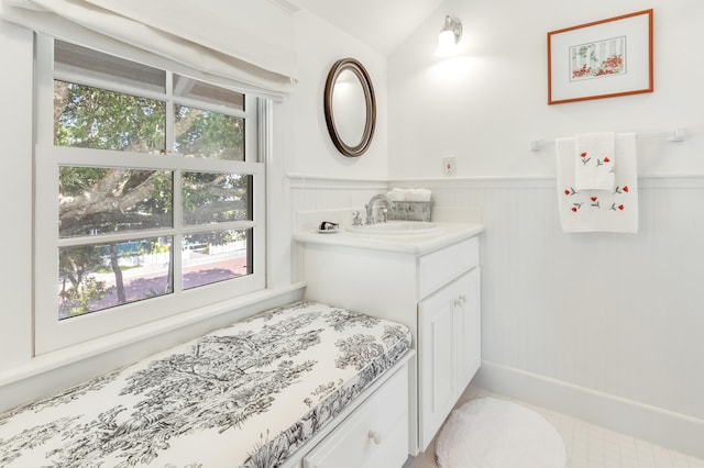 bathroom featuring vanity, a wealth of natural light, and wainscoting