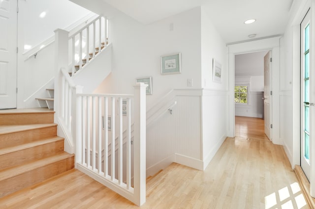 stairs with recessed lighting, a wainscoted wall, and wood finished floors