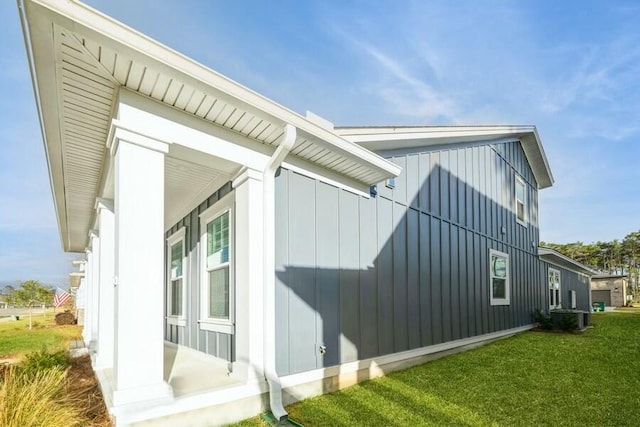 view of home's exterior with central AC, a yard, and board and batten siding