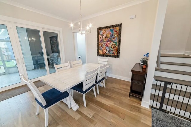 dining area with baseboards, light wood-style flooring, ornamental molding, stairs, and a notable chandelier