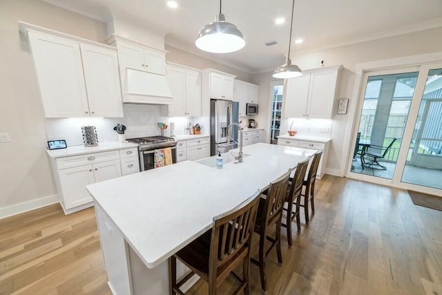 kitchen featuring appliances with stainless steel finishes, light countertops, custom range hood, and white cabinetry