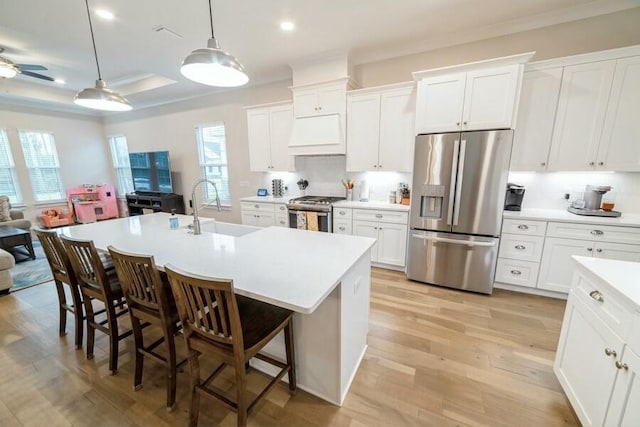 kitchen with white cabinetry, stainless steel appliances, a sink, and light countertops