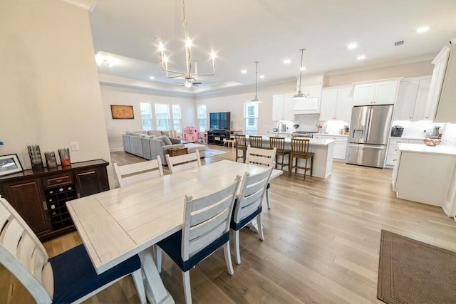 dining space with an inviting chandelier, light wood-style flooring, visible vents, and recessed lighting