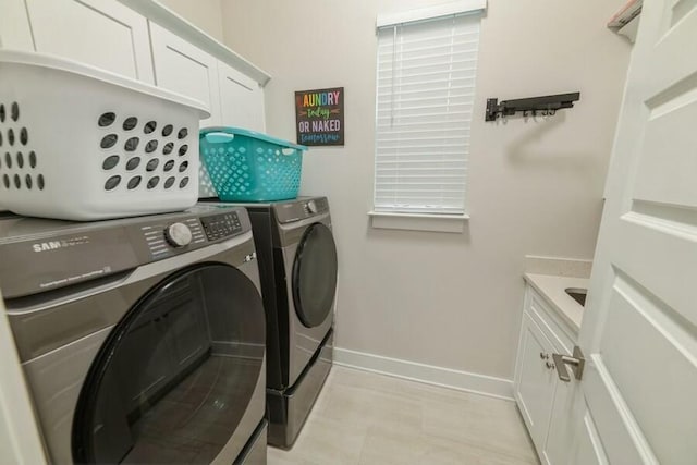 laundry room featuring baseboards, cabinet space, and washer and dryer