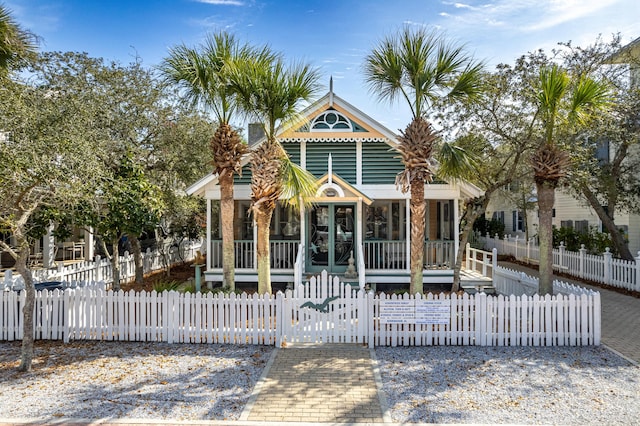 view of front facade with a porch, a fenced front yard, and a gate