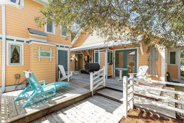 wooden deck with french doors and a grill