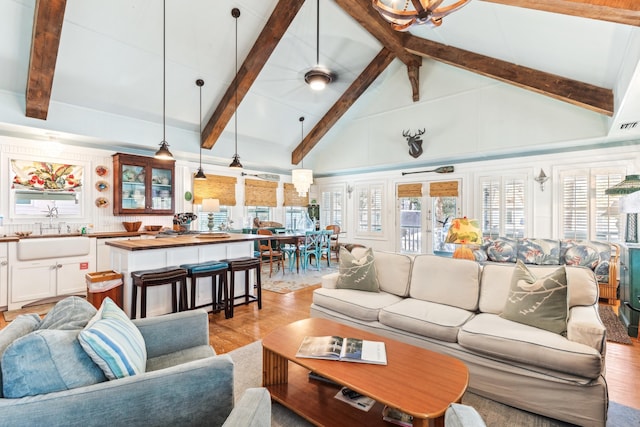 living room featuring a healthy amount of sunlight, light wood-style floors, and high vaulted ceiling