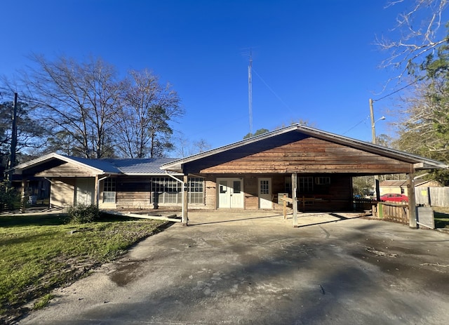 view of front of home featuring a carport, metal roof, and driveway