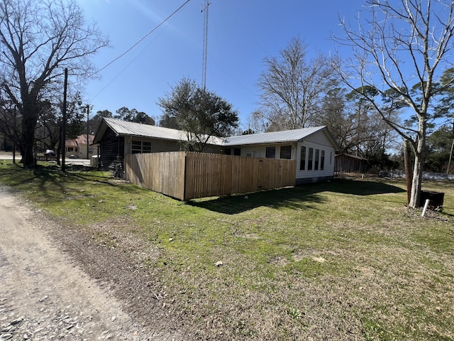 view of home's exterior with metal roof and a lawn